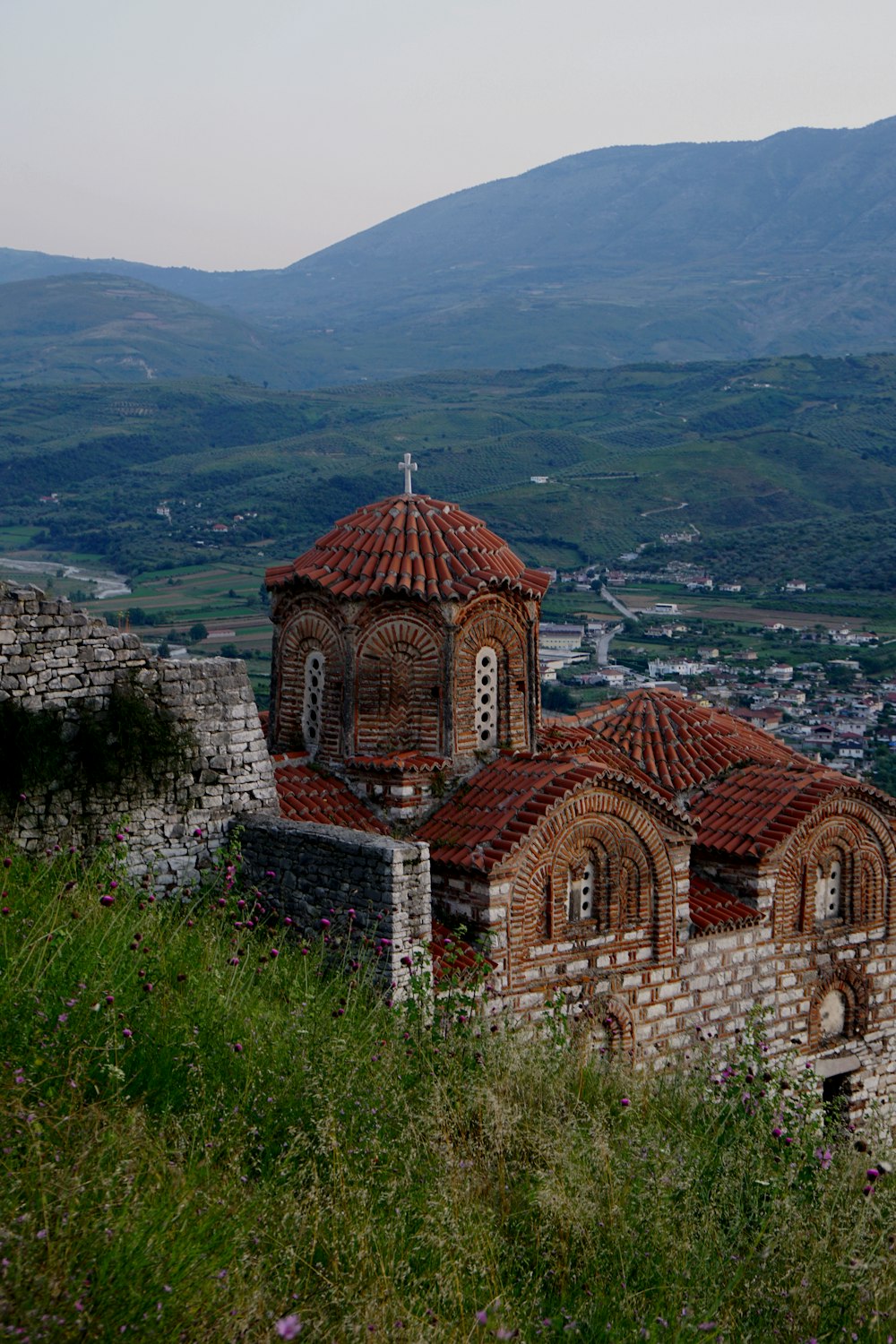 an old church on a hill overlooking a town