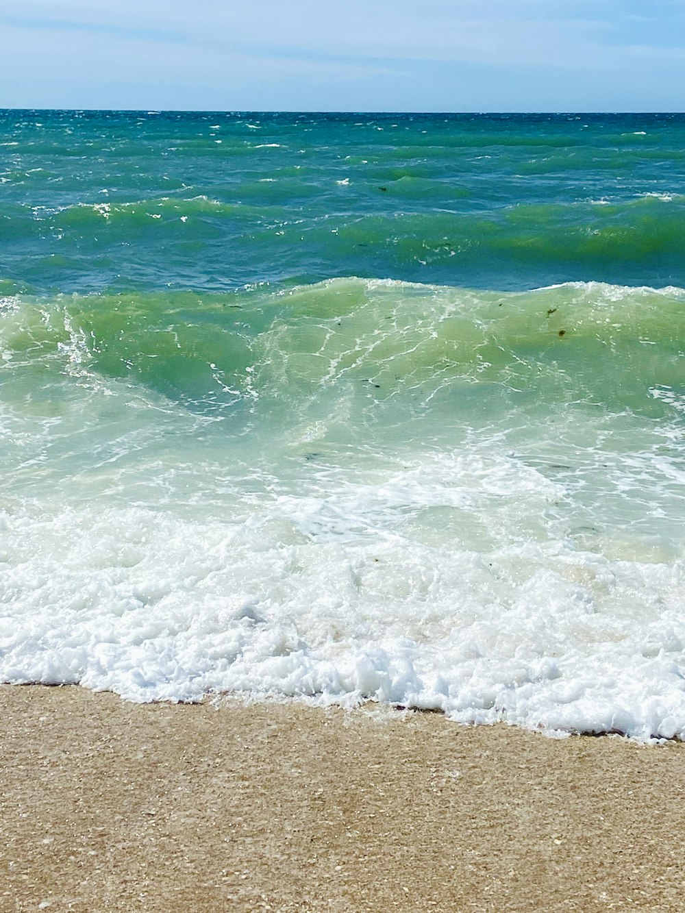 Una persona parada en una playa junto al océano