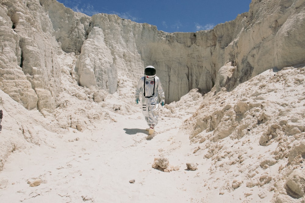 a man in a space suit walking through a desert