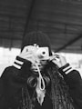 a black and white photo of a person holding a camera