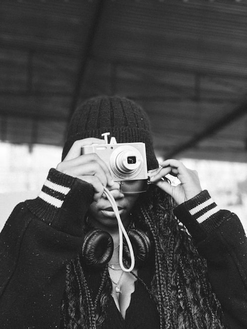 a black and white photo of a person holding a camera