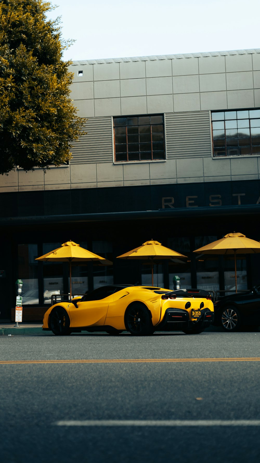 a yellow sports car parked in front of a restaurant