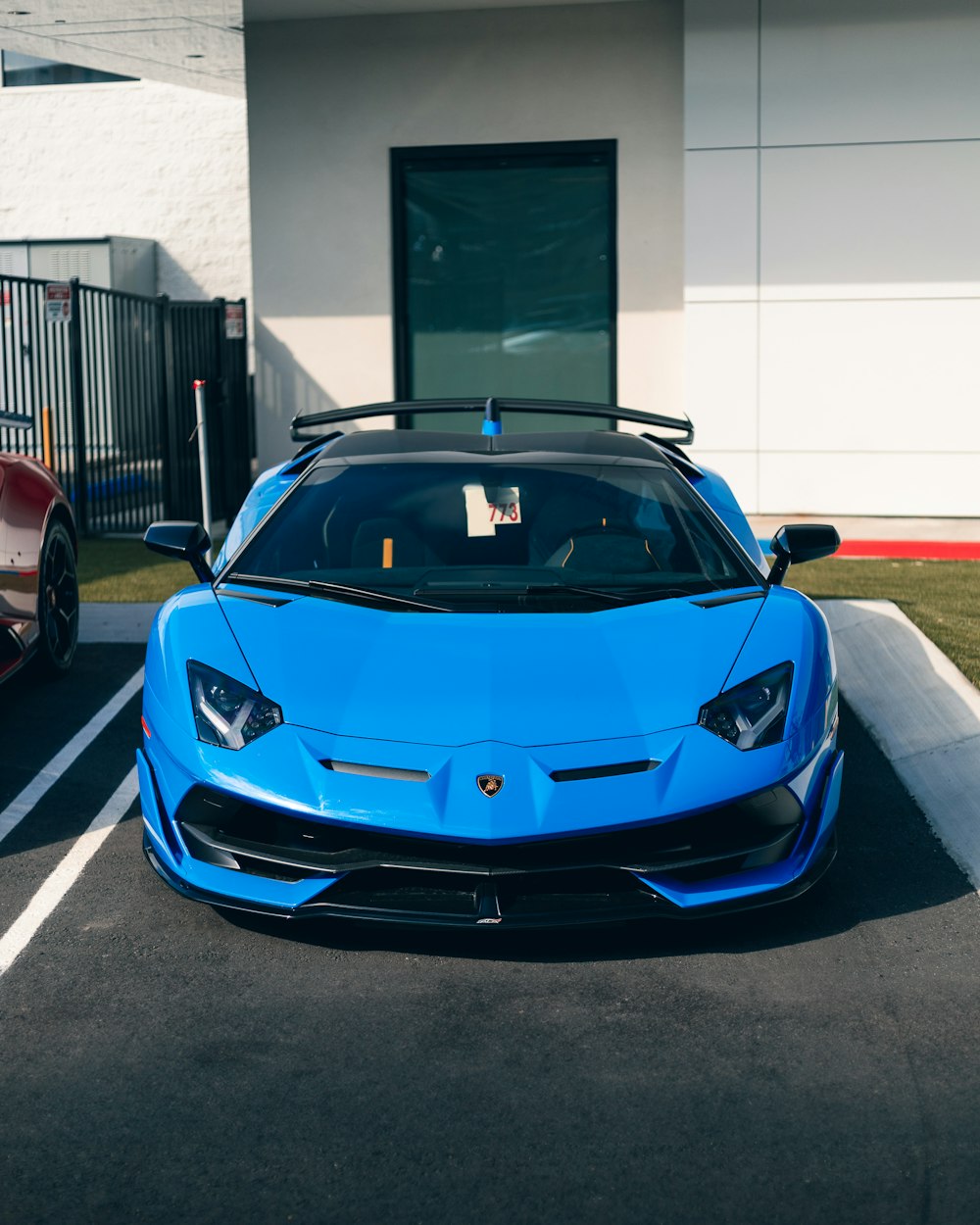 Un auto deportivo azul estacionado en un estacionamiento