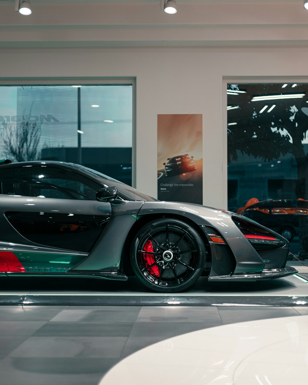 a grey and green sports car in a showroom