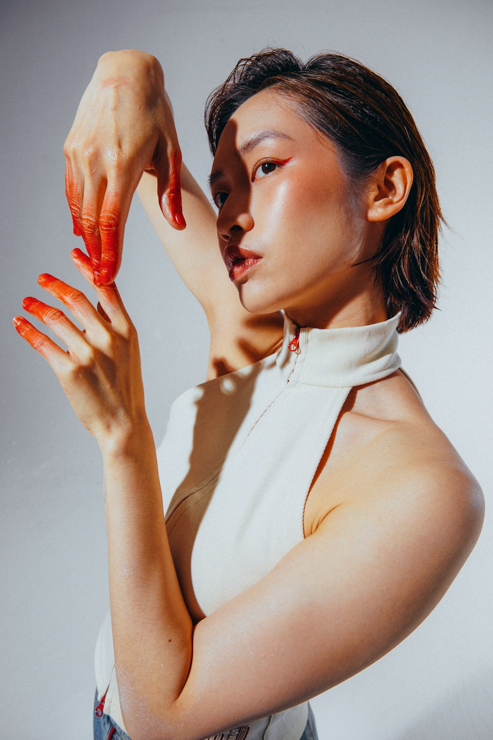 a woman in a white shirt holding a red object