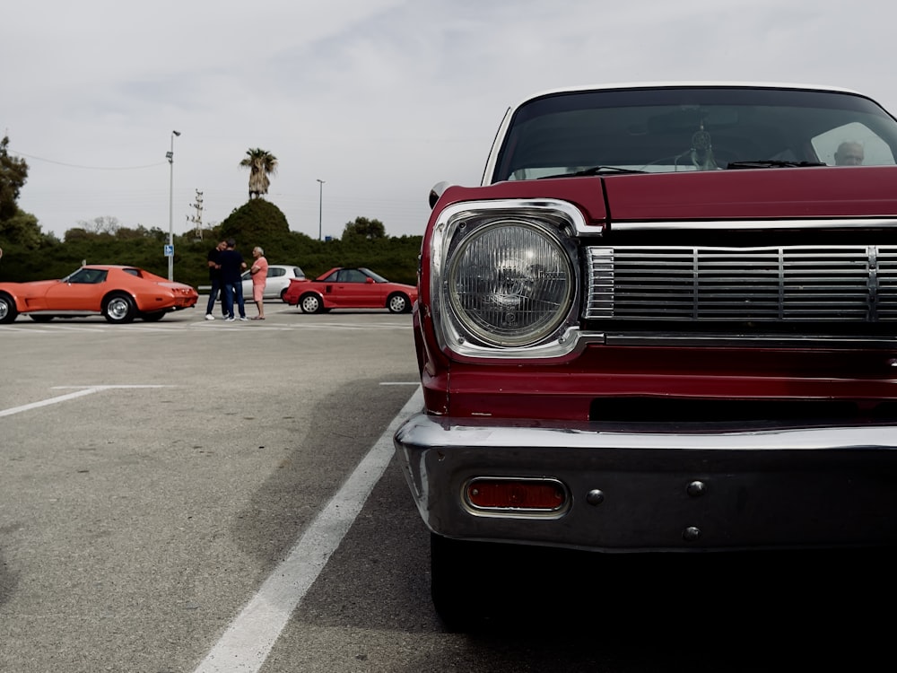 a red car parked in a parking lot next to other cars