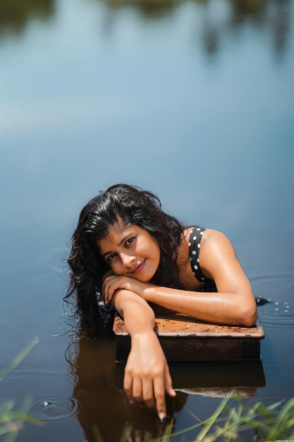 a woman in a bikini laying on top of a body of water