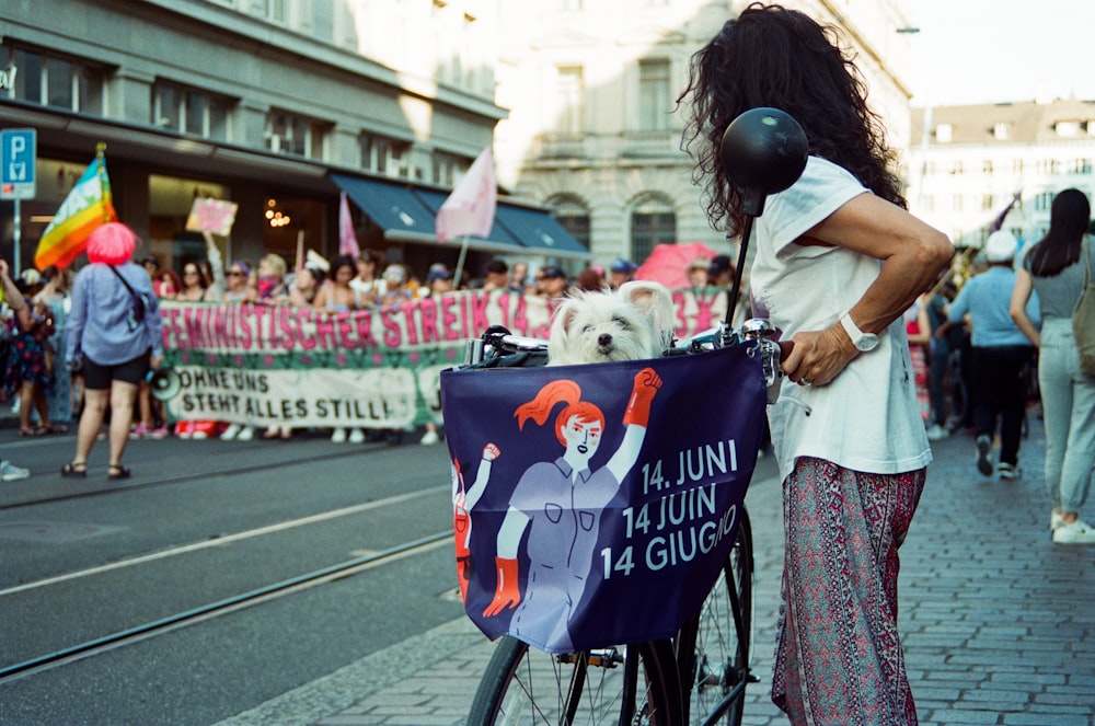 a woman standing next to a bike with a sign on it