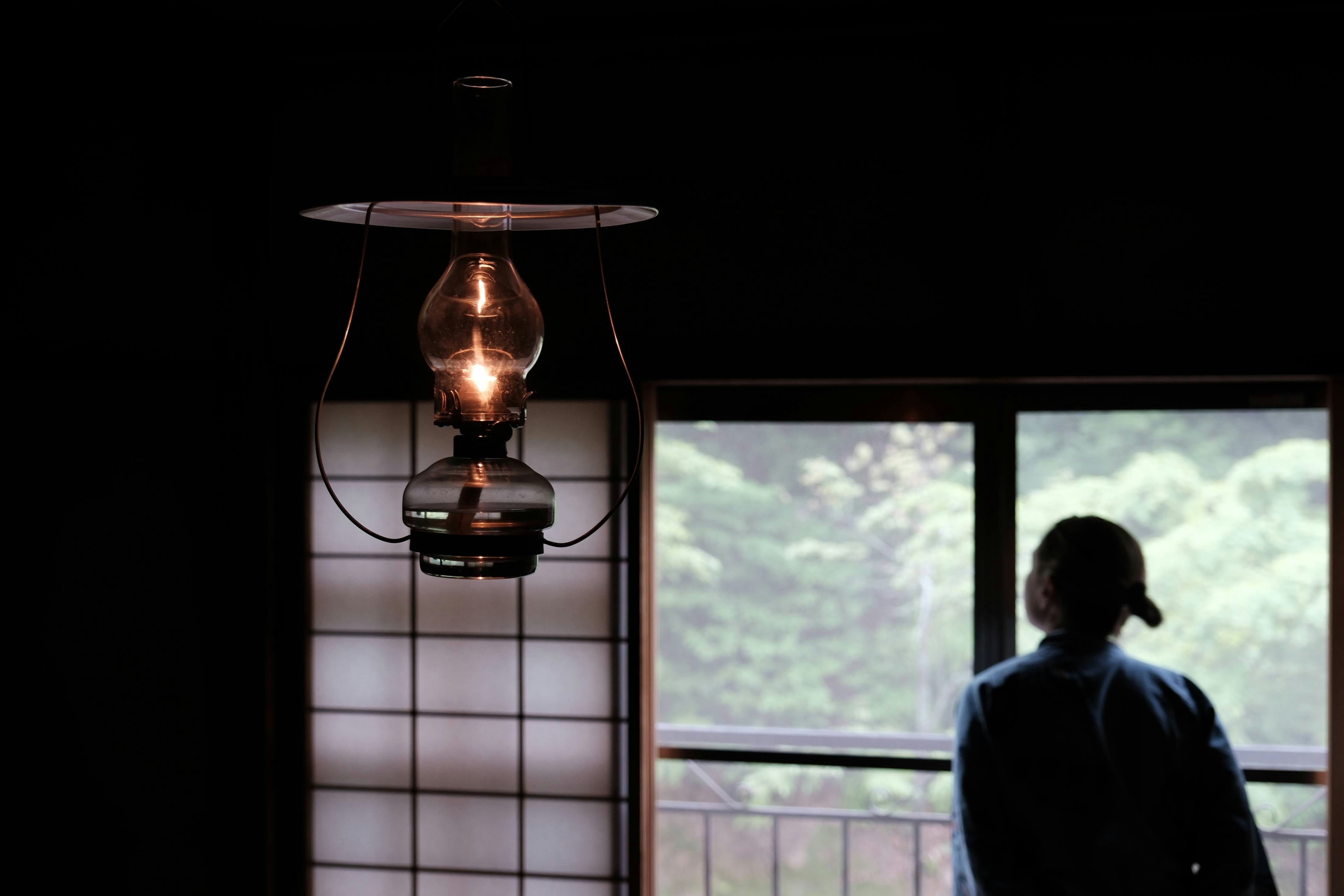 a person standing in a dark room next to a window