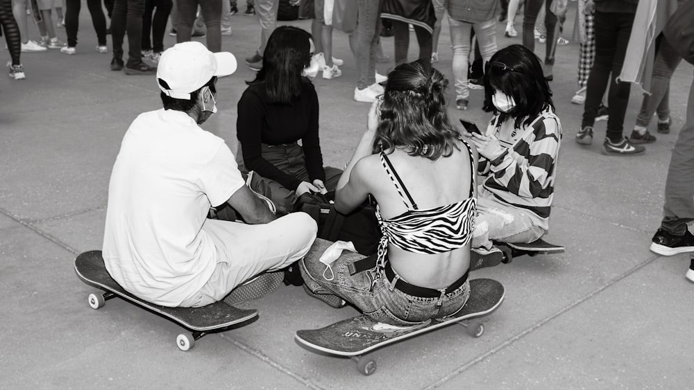 a group of people sitting on top of skateboards