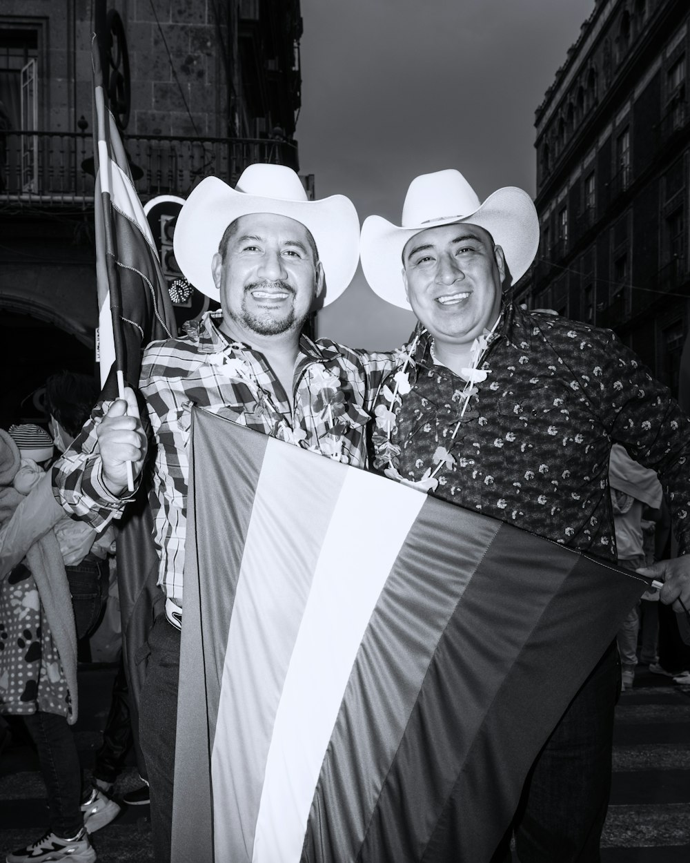 a couple of men standing next to each other holding a flag