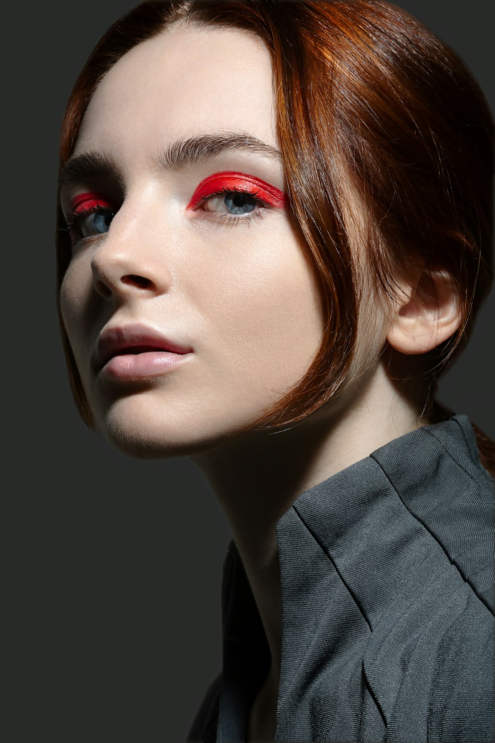 a woman with red eyeliners and red lipstick