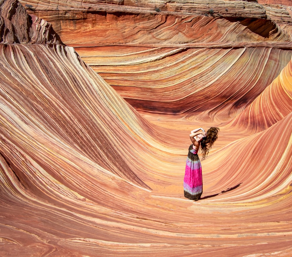 a woman in a long dress standing in a canyon