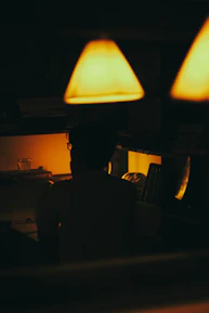 An editor reviewing a manuscript under soft, warm lighting with starry wall art in the background.