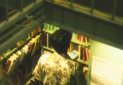 A smiling customer browsing through books in the store’s book category.