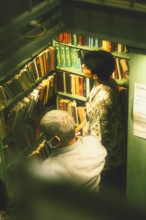 Two members exchanging books in a cozy home setting.