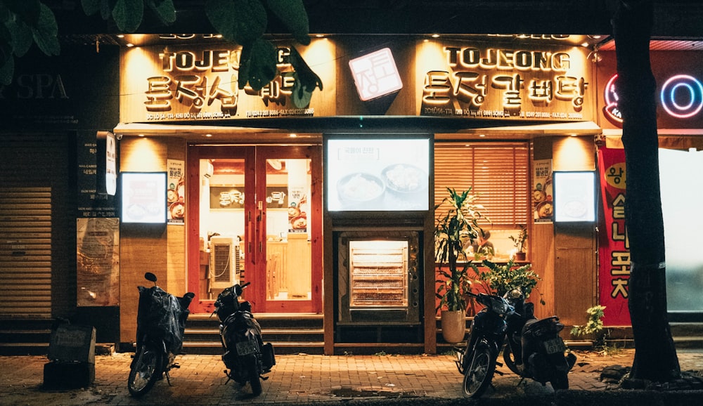 two motorcycles are parked outside of a restaurant