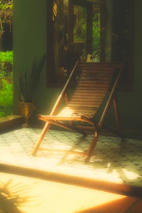 A solid wood outdoor leisure chair set on a sunlit patio surrounded by greenery.