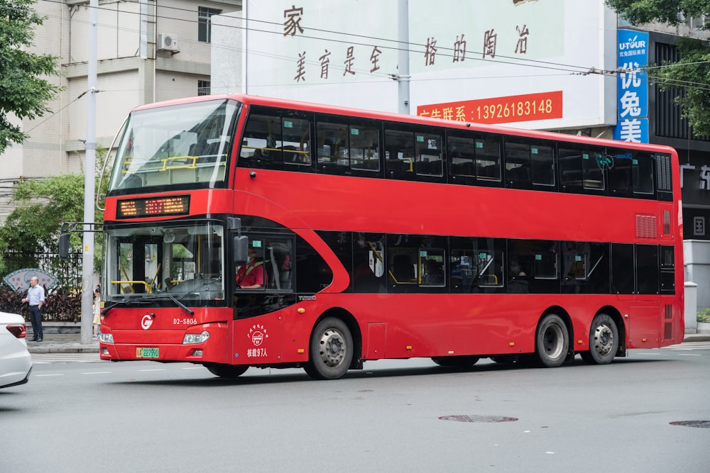 a red double decker bus driving down a street