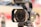A professional 4K video camera is prominently featured, showcasing the lens with visible branding details. The camera appears mounted on a tripod, hinting at a setup for filming or photography. The background is blurred, emphasizing the camera as the focal point.