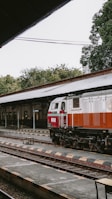 a red and white train pulling into a train station