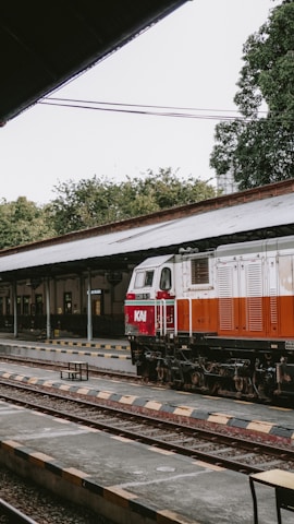 a red and white train pulling into a train station
