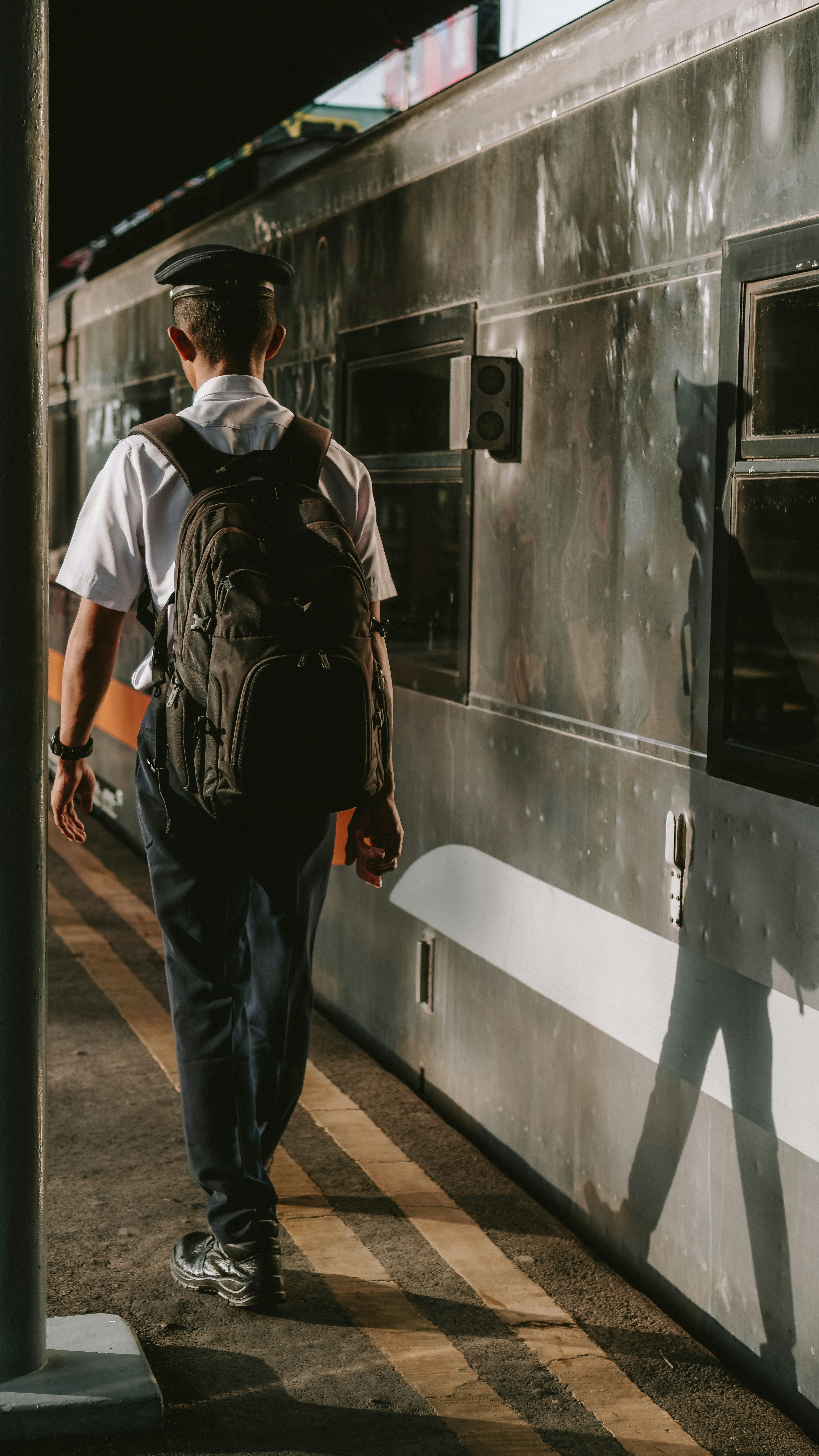 A machinist walking alone in the evening at Surabaya Gubeng train station.