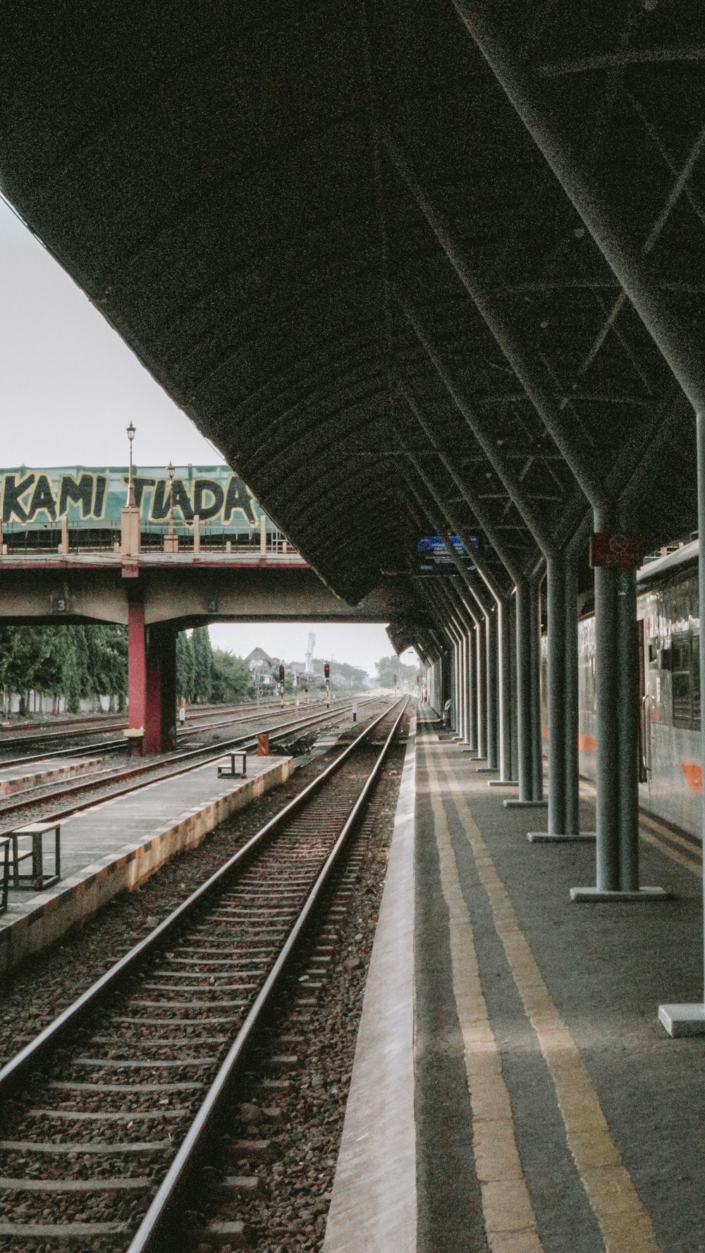 uma estação de trem com um trem nos trilhos