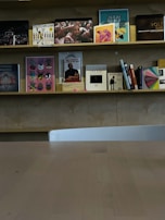 A set of minimalist wooden shelves displaying books and decorative items.
