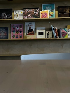 A set of minimalist wooden shelves displaying books and decorative items.
