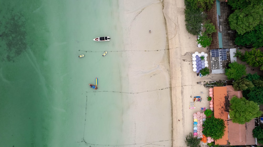 an aerial view of a beach with a boat in the water