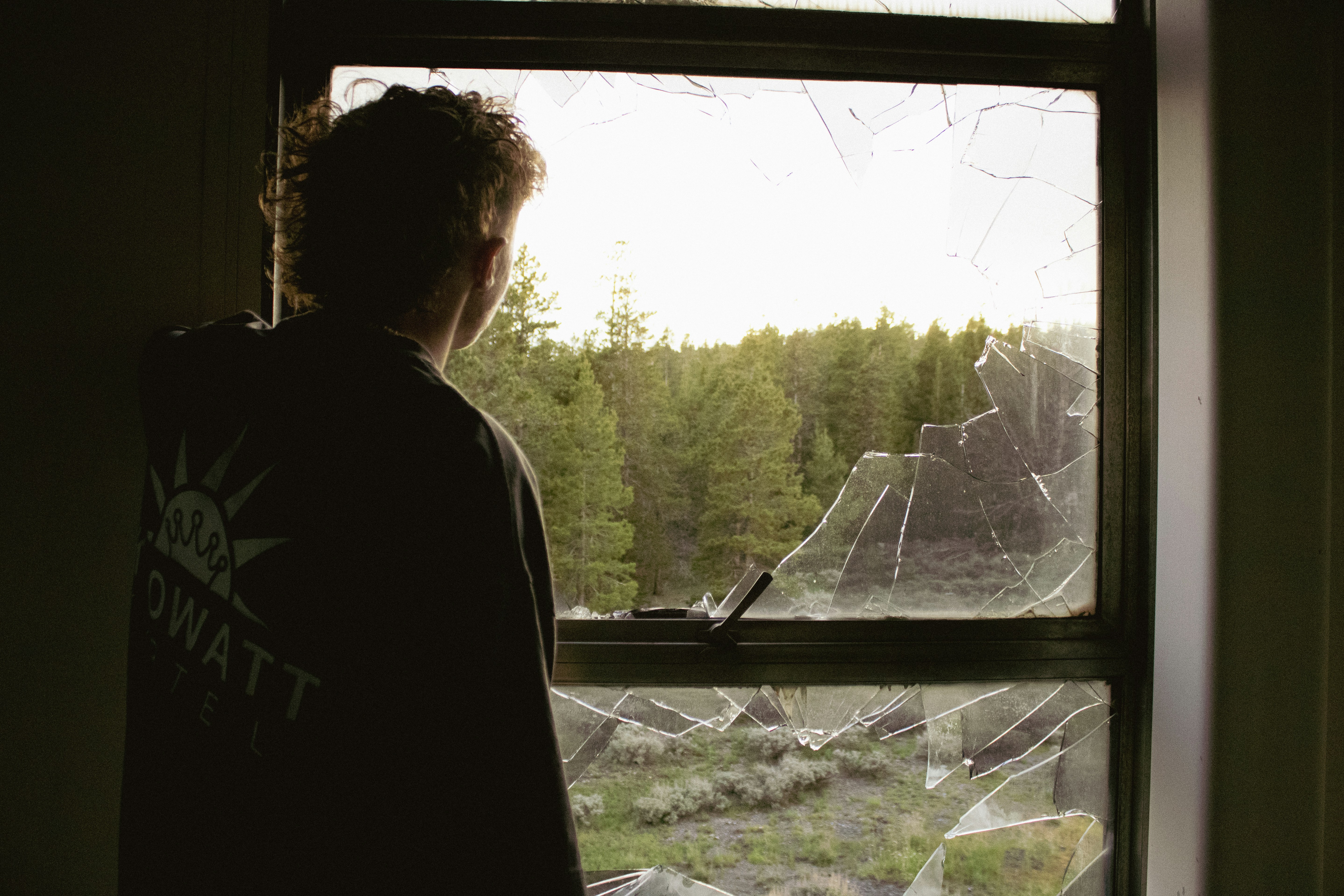 a man looking out of a broken window