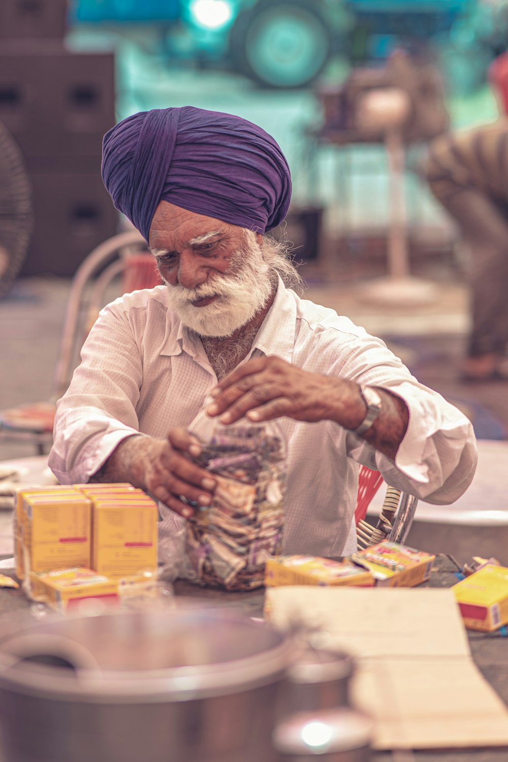 a man in a turban is putting food in a container