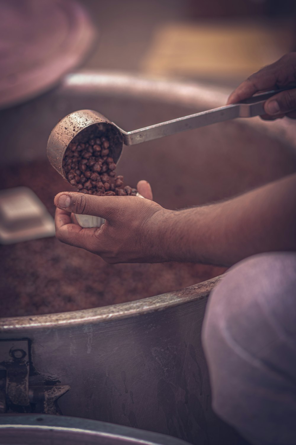 a person holding a spoon over a bowl of food