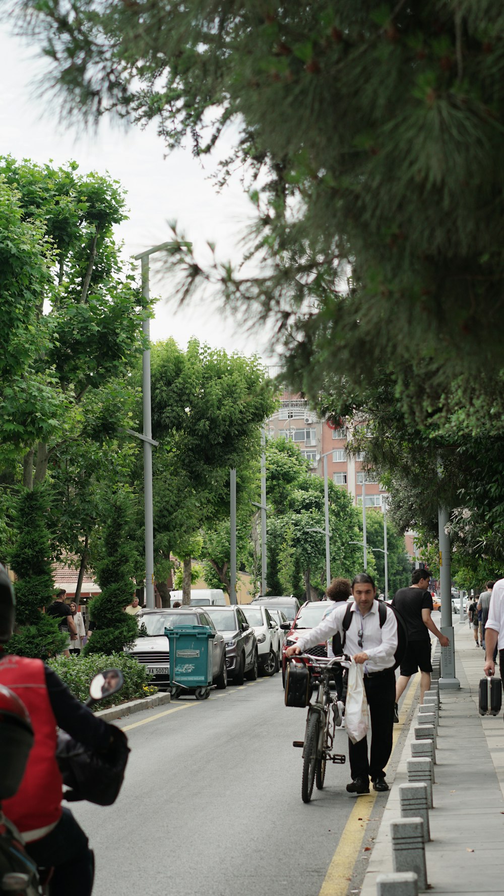 a man riding a bike down a street next to a sidewalk