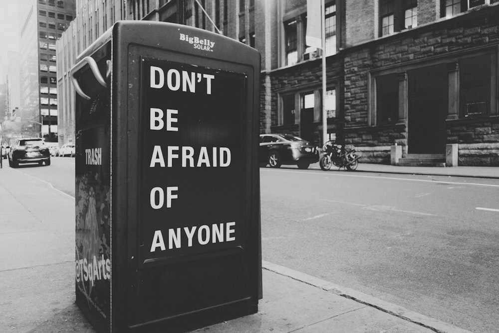 a black and white photo of a sign on the side of a street