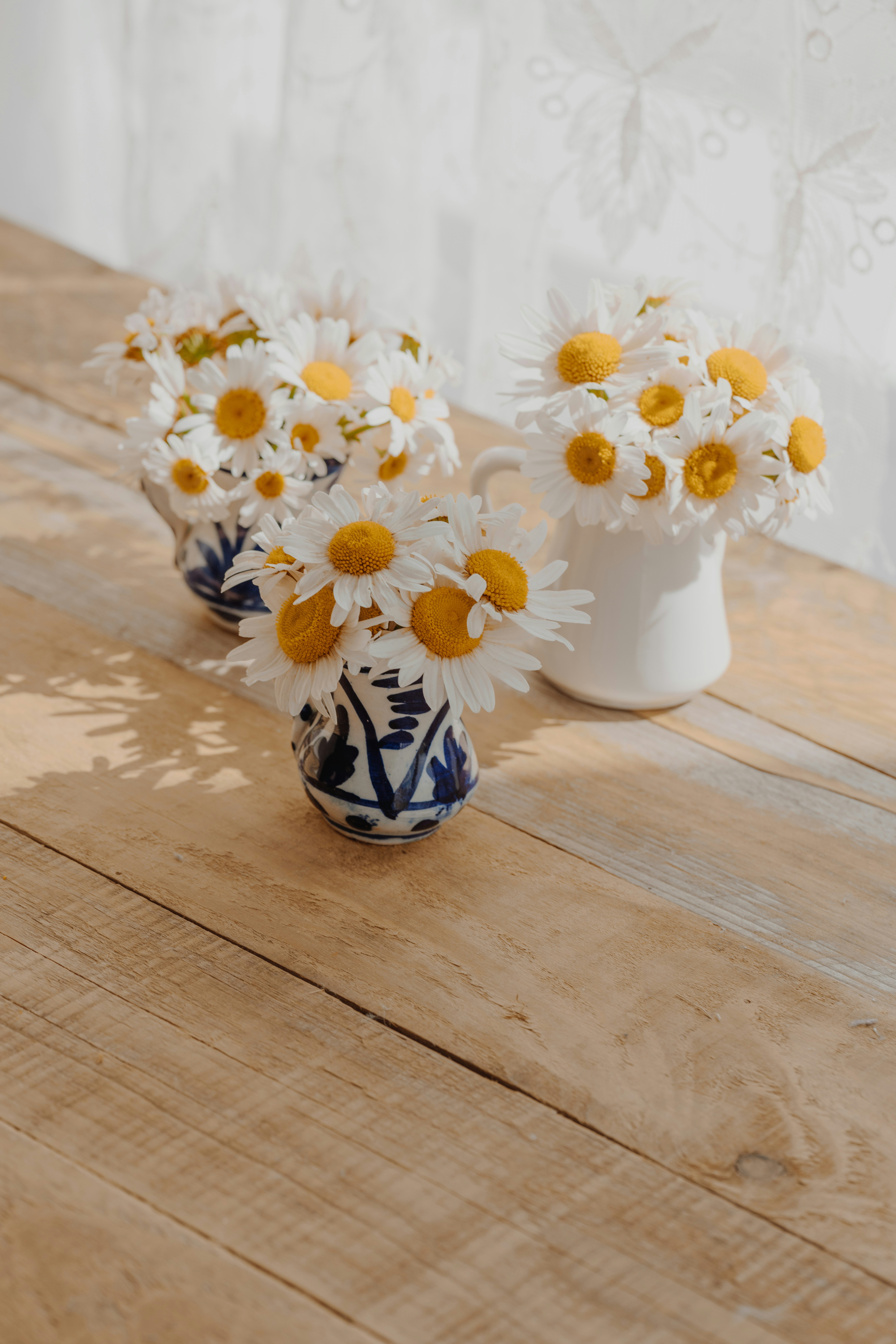 A couple of vases filled with yellow and white flowers photo – Free ...