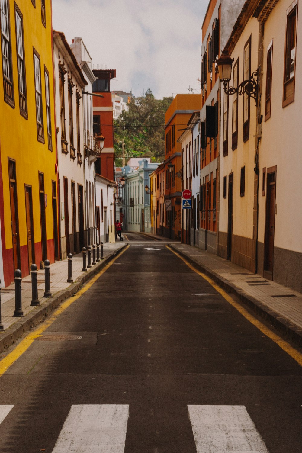 une rue vide avec un bâtiment jaune sur le côté