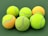 Close-up of colorful tennis balls arranged on a wooden surface.