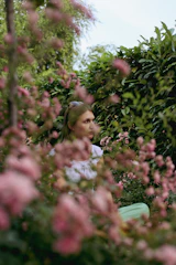 A soft-focus image of a person sitting quietly in a peaceful natural setting, reflecting a moment of calm amidst stress.