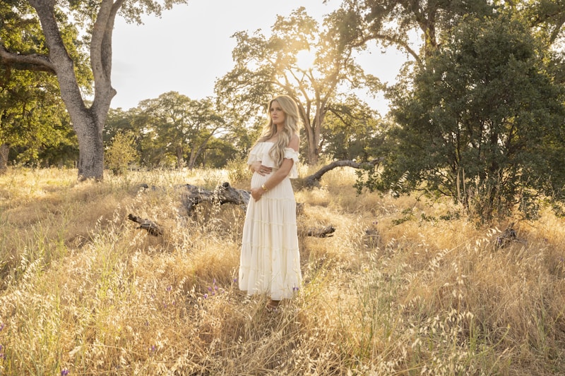 a woman in a white dress standing in a field