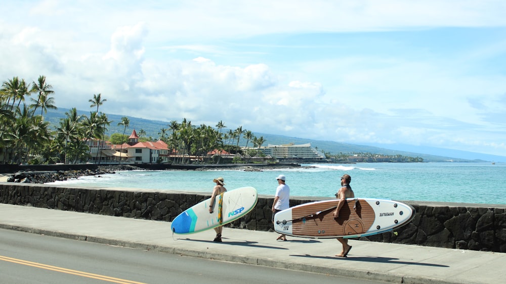 a group of people walking down a street with surfboards