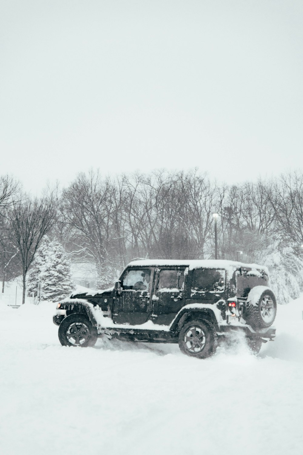 Un jeep conduciendo a través de un campo cubierto de nieve