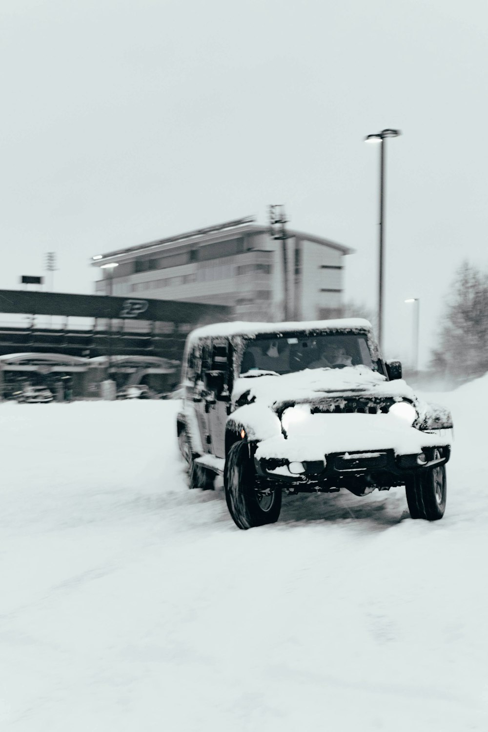 a jeep driving down a snow covered road