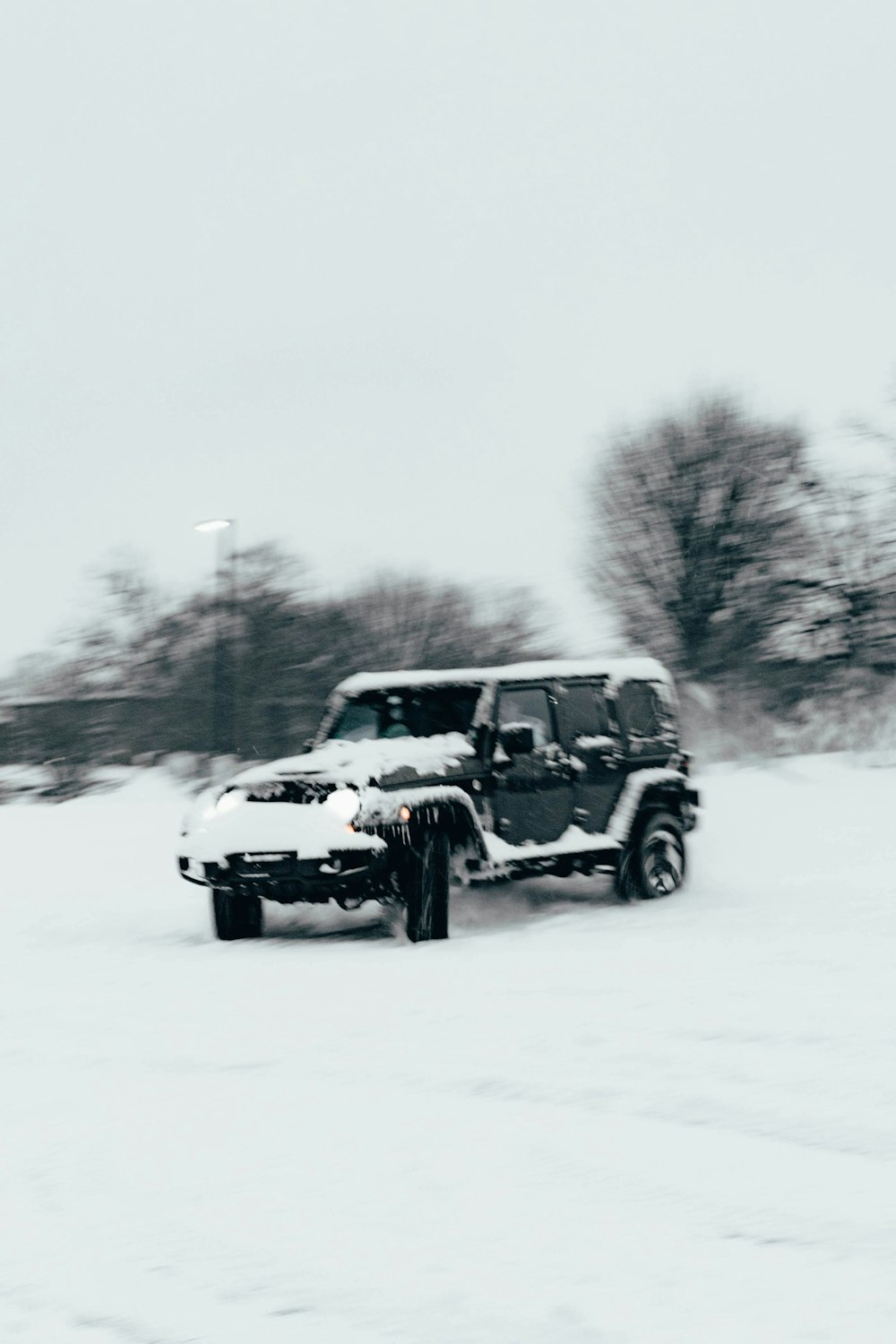 um jipe dirigindo por uma estrada coberta de neve