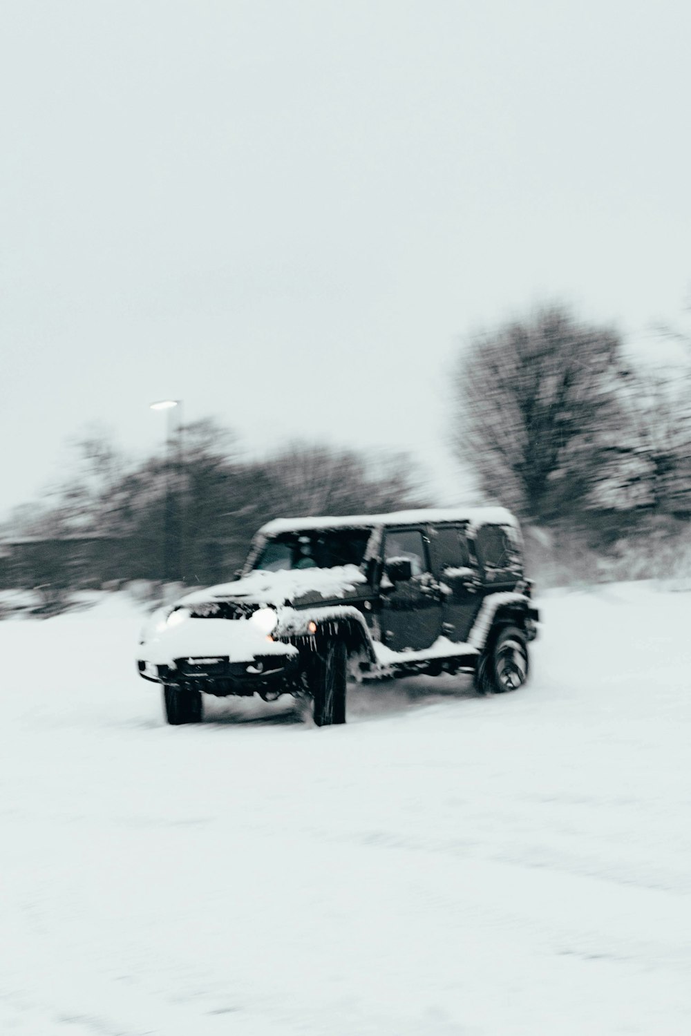 a jeep driving down a snow covered road