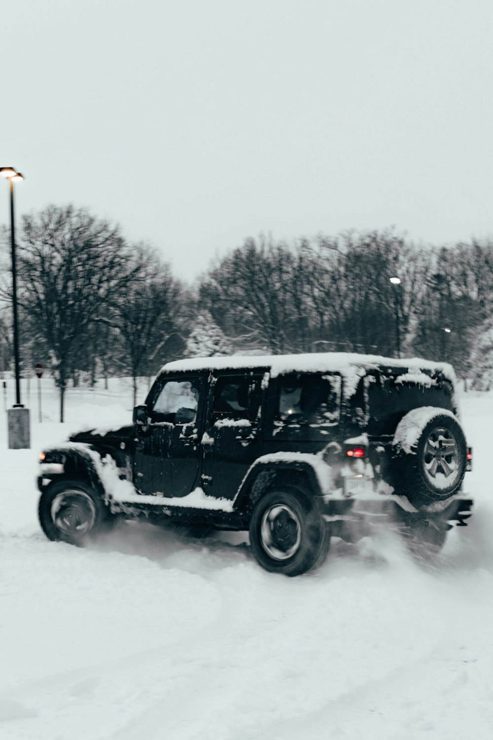 a jeep driving down a snow covered road