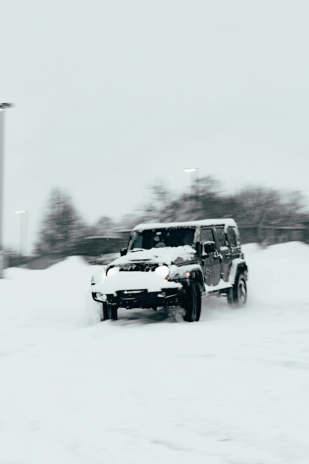 a jeep driving down a snow covered road