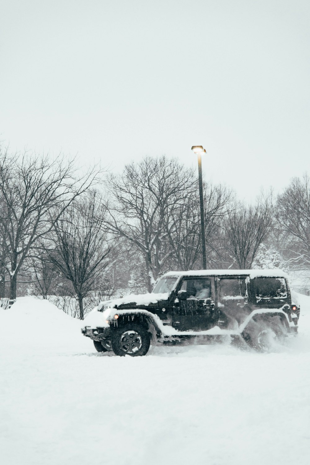 a jeep driving down a snow covered road