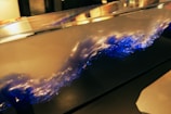 A mesmerizing display of liquid dynamics within a transparent container. The swirling fluid exhibits a captivating blend of blue and white colors, resembling a crashing wave or turbulent flow. The lighting highlights the fluid's motion, creating an artistic and dynamic visual.